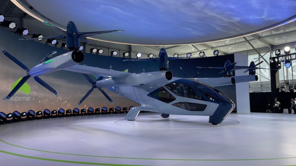 an electric air taxi paint in white sits on a platform at CES 2024